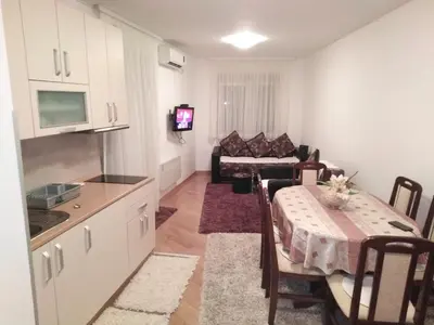 a kitchen and living room with a table and a couch at FEEL LIKE HOME in Vrnjačka Banja