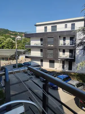 a parking lot with cars parked in front of a building at FEEL LIKE HOME in Vrnjačka Banja