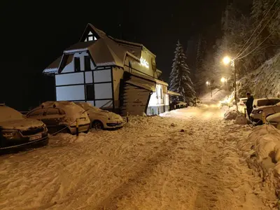 a house on a snow covered street at night at Vila Irina - Studio 11 lux in Kopaonik