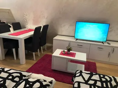 a living room with a white table and a television at Top Kop in Kopaonik