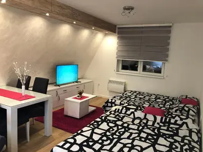 a bedroom with a black and white bed and a television at Top Kop in Kopaonik