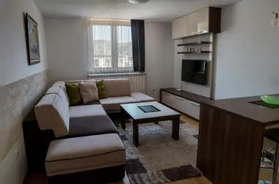 a living room with a couch and a table at VILA JEZERO in Kopaonik