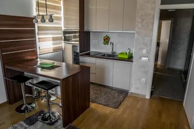 a kitchen with a wooden table and a counter top at VILA JEZERO in Kopaonik