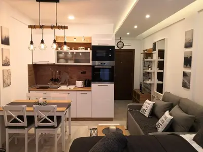 a living room and kitchen with a couch and a table at Lux Suite S5 Milmari Resort in Kopaonik