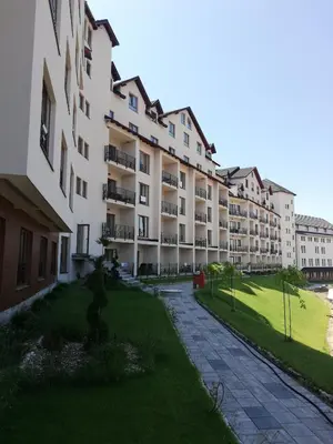 a large apartment building with a lawn in front of it at Lux Suite S5 Milmari Resort in Kopaonik