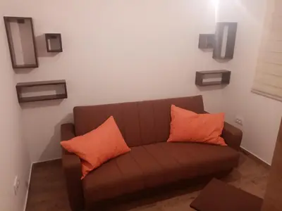 a brown couch with two orange pillows in a room at Iznad oblaka A1 in Kopaonik
