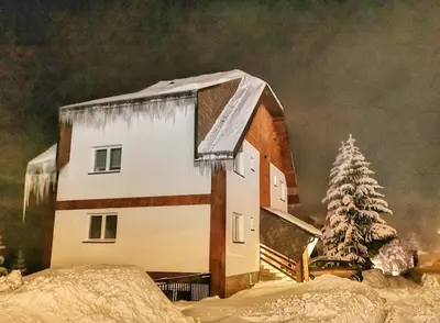 a house covered in snow with icicles on it at Iznad oblaka A1 in Kopaonik