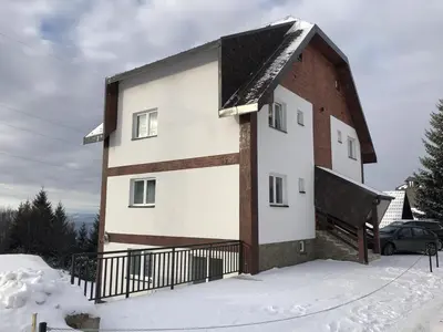 a white and brown building in the snow at Iznad oblaka A1 in Kopaonik