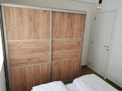 a large wooden closet in a bedroom with a bed at Iznad oblaka A1 in Kopaonik