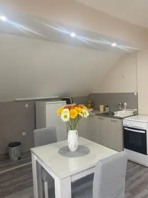 a kitchen with a table with a vase of flowers on it at Apartment 