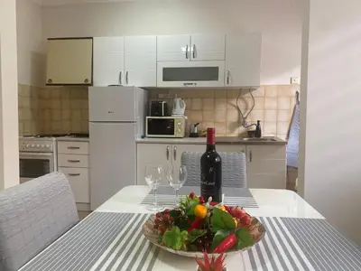 a table with a plate of fruit and a bottle of wine at Apartment 