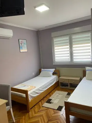 a small room with two beds and a chair at Apartment 