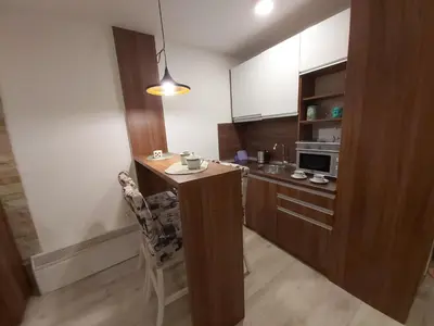 a small kitchen with a table and a microwave at AMI apartman Kopaonik in Kopaonik