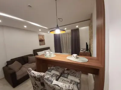 a living room with a table and a couch at AMI apartman Kopaonik in Kopaonik