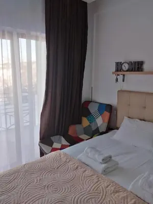 a bedroom with a bed and a chair next to a window at Apartment Deluxe Sunny Valley Milmari S8 in Kopaonik