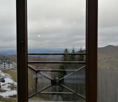 a window with a clock on the side of it at Milmari P39 Kopaonik in Kopaonik