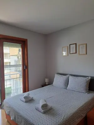a white bedroom with a bed with towels on it at Studio Mišel in Vrnjačka Banja