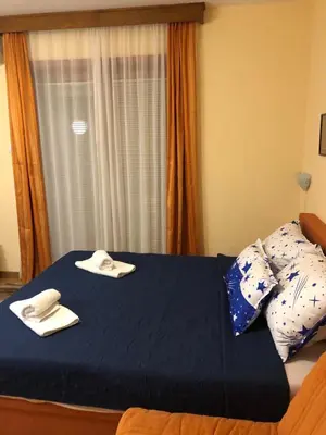 a bedroom with a blue bed with towels on it at Studio Mišel in Vrnjačka Banja