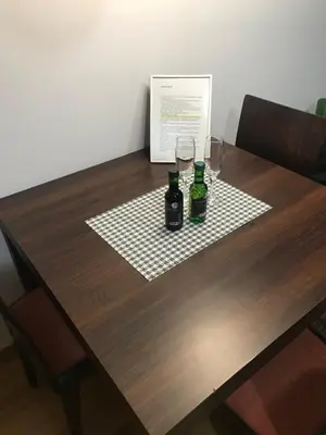 a wooden table with two bottles and glasses on it at Studio Mišel in Vrnjačka Banja