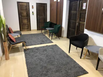 a waiting room with chairs and tables and a rug at Apartman VR46 in Kopaonik