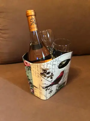 a bottle of wine in a container with two wine glasses at Apartman VR46 in Kopaonik