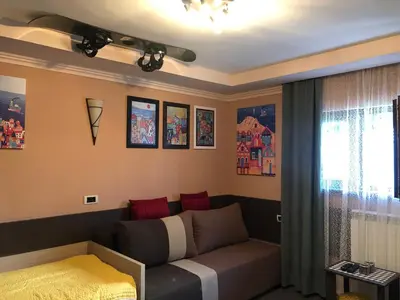 a living room with a couch and a window at Apartman VR46 in Kopaonik