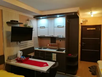 a kitchen with white cabinets and a red counter top at Apartman VR46 in Kopaonik
