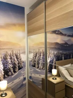 a bedroom with a painting of a winter scene on the wall at Silver Kop apartmani in Kopaonik