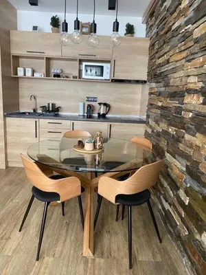 a dining room with a glass table and chairs at Silver Kop apartmani in Kopaonik