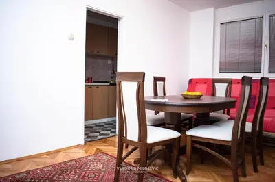 a dining room table and chairs in a room at Dusko dugousko in Niš