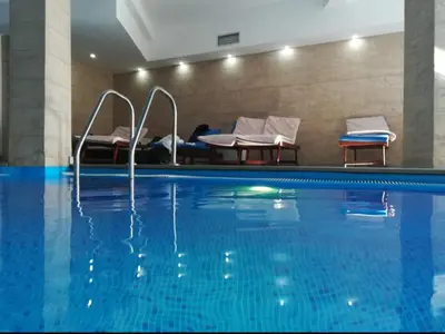 a hotel swimming pool with two chairs and a bed at Apartman D&V Milmari Resort S10 in Kopaonik