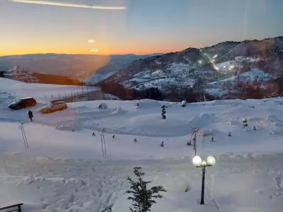 a group of people skiing down a snow covered mountain at Apartman D&V Milmari Resort S10 in Kopaonik