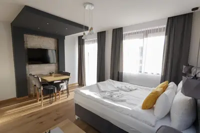 a bedroom with a bed and a table and a desk at Harmonija Resort - Harmonija Kopaonik in Kopaonik