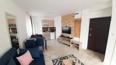 a living room with a blue couch and a television at Panorama Apartman - Milmari L47 in Kopaonik