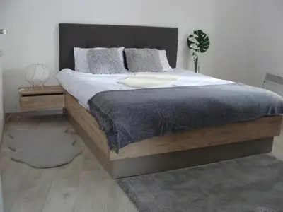 a bedroom with a large bed with a wooden headboard at Panorama Apartman - Milmari L47 in Kopaonik
