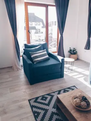 a living room with a blue couch and a table at Panorama Apartman - Milmari L47 in Kopaonik