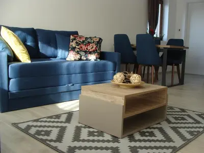 a living room with a blue couch and a table at Panorama Apartman - Milmari L47 in Kopaonik