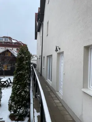 a walkway next to a building with snow on the ground at Kopaonik apartmani u Kraljevim Čardacima , Čar 27 i 6-13 in Kopaonik