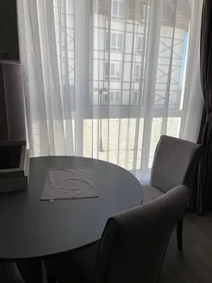a table and a chair in a room with a window at Kopaonik apartmani u Kraljevim Čardacima , Čar 27 i 6-13 in Kopaonik