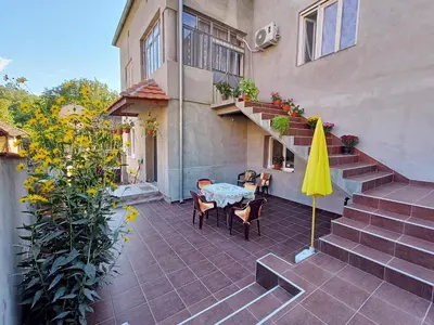 a patio with a table and a yellow umbrella at Kuca za odmor RADMILA - Rogljevacke pivnice in Rogljevo