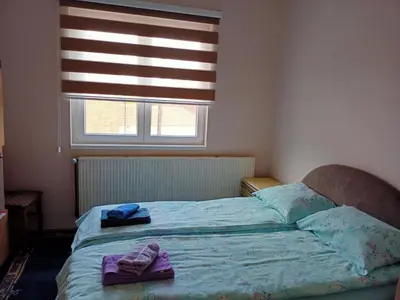 a bedroom with a bed with towels and a window at Kuca za odmor RADMILA - Rogljevacke pivnice in Rogljevo