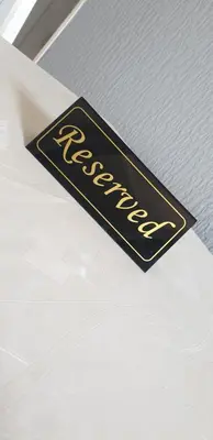 a black and gold sign on top of a bed at Apartman Sava in Niš