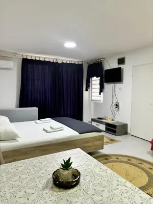 a hotel room with two beds and a table at Apartman Sava in Niš