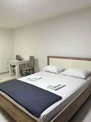 a large bed with two towels on top of it at Apartman Sava in Niš