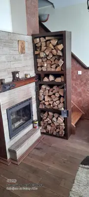 a room with a fireplace and a pile of wood at Like Home Lux, Apartman A9 in Kopaonik