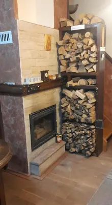 a fireplace with a pile of fire wood at Like Home Lux, Apartman A9 in Kopaonik