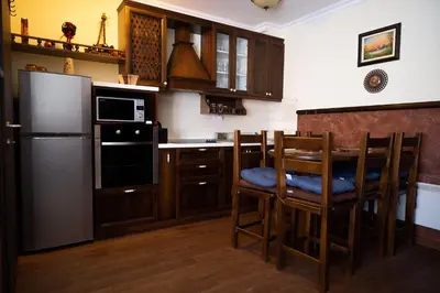 a kitchen with a table and chairs and a refrigerator at Like Home Lux, Apartman A9 in Kopaonik