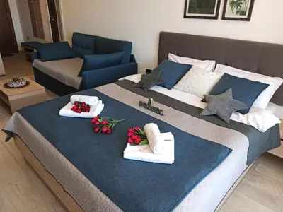 a large bed with towels on it with a couch at Milmari S30 in Kopaonik