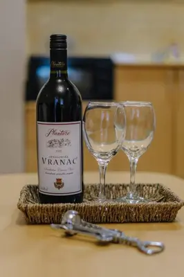 a bottle of wine and two wine glasses on a table at Košuta 21 Center Duplex Apartment, Brzeće in Brzeće