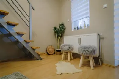 two stools in a living room with a staircase at Košuta 21 Center Duplex Apartment, Brzeće in Brzeće